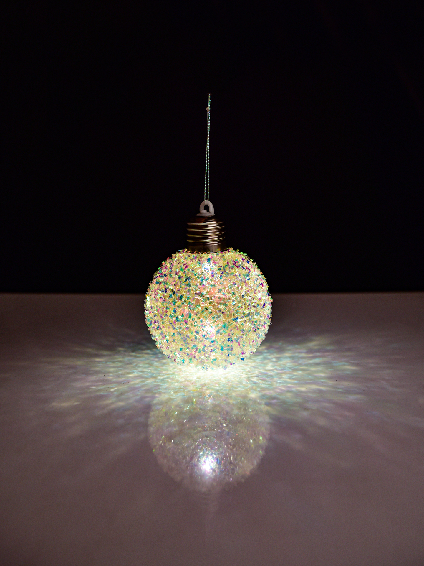 8 cm svítící LED koule na povrchu s barevnými lametami